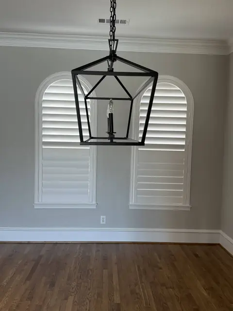 White plantation shutters on arched windows