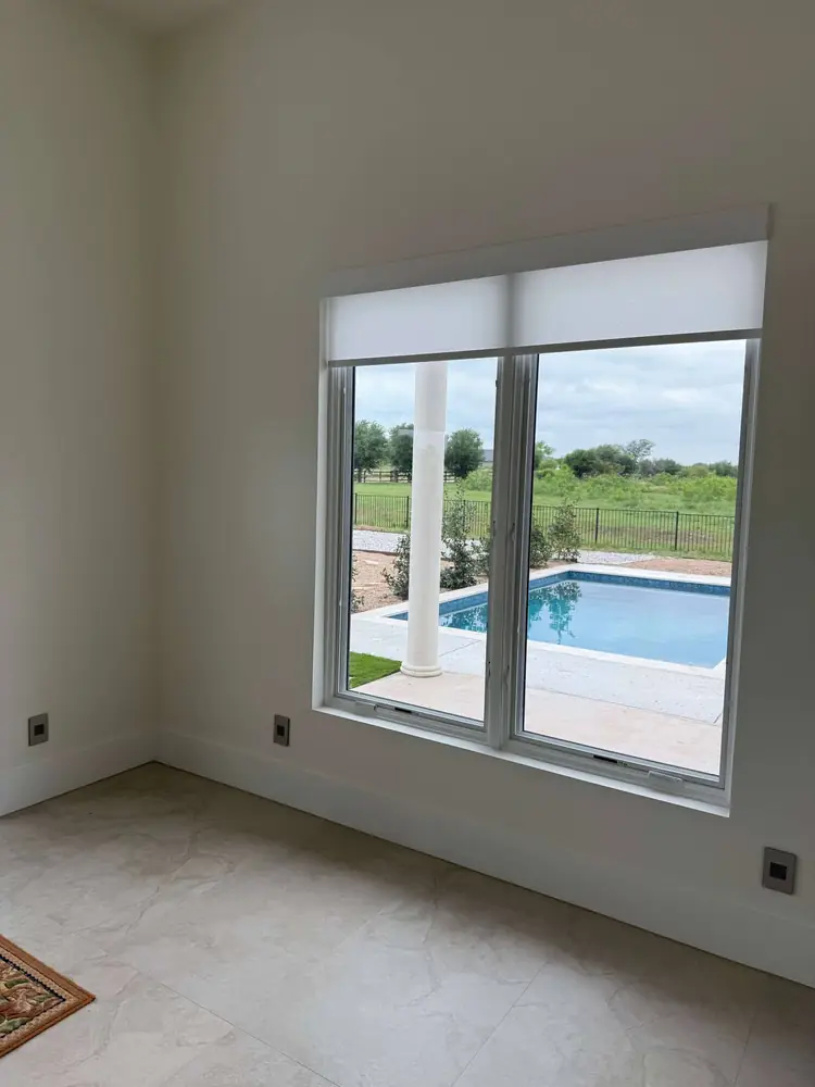 Shade installed over French doors facing a pool