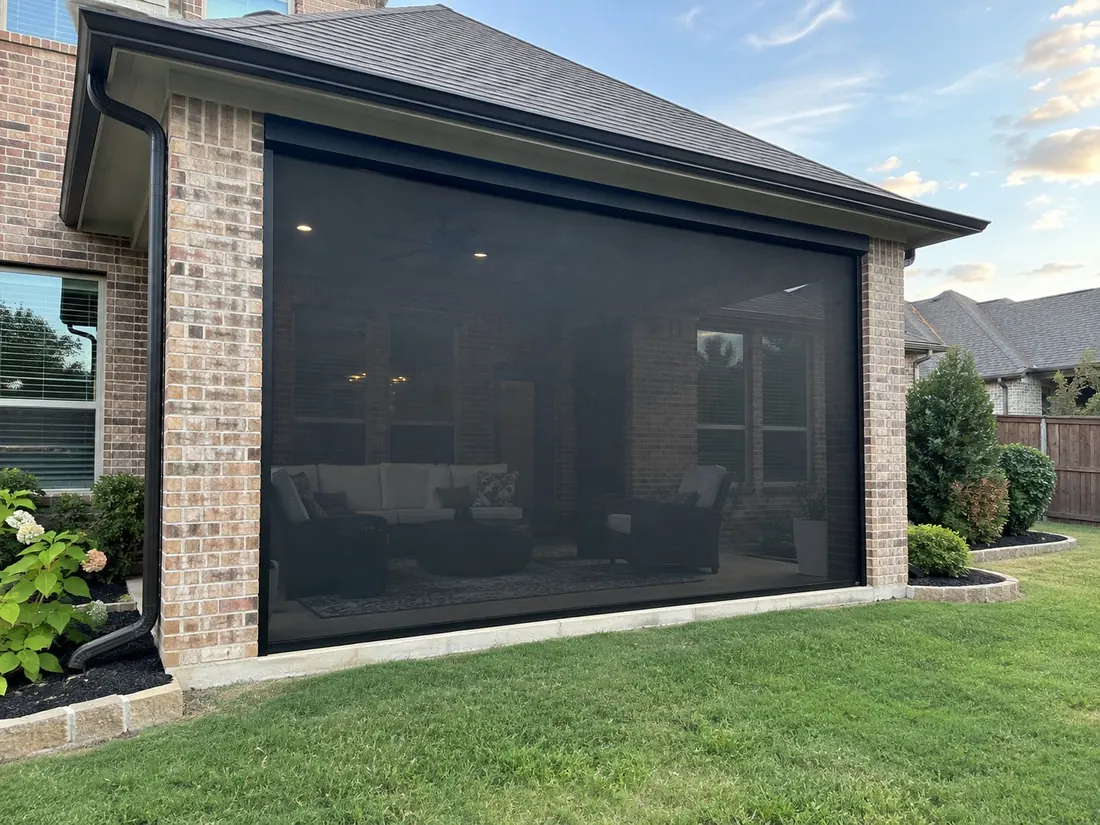 Motorized screens lowered on a covered brick patio