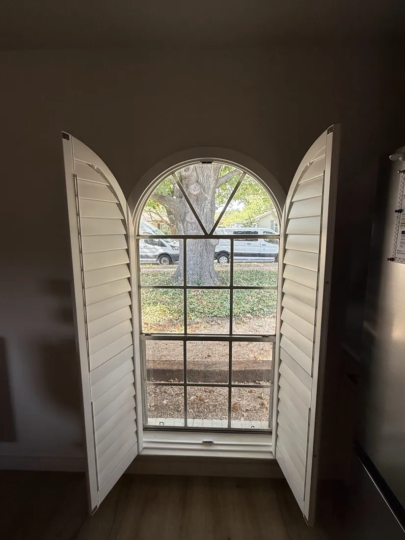 Arched plantation shutters with the panels open